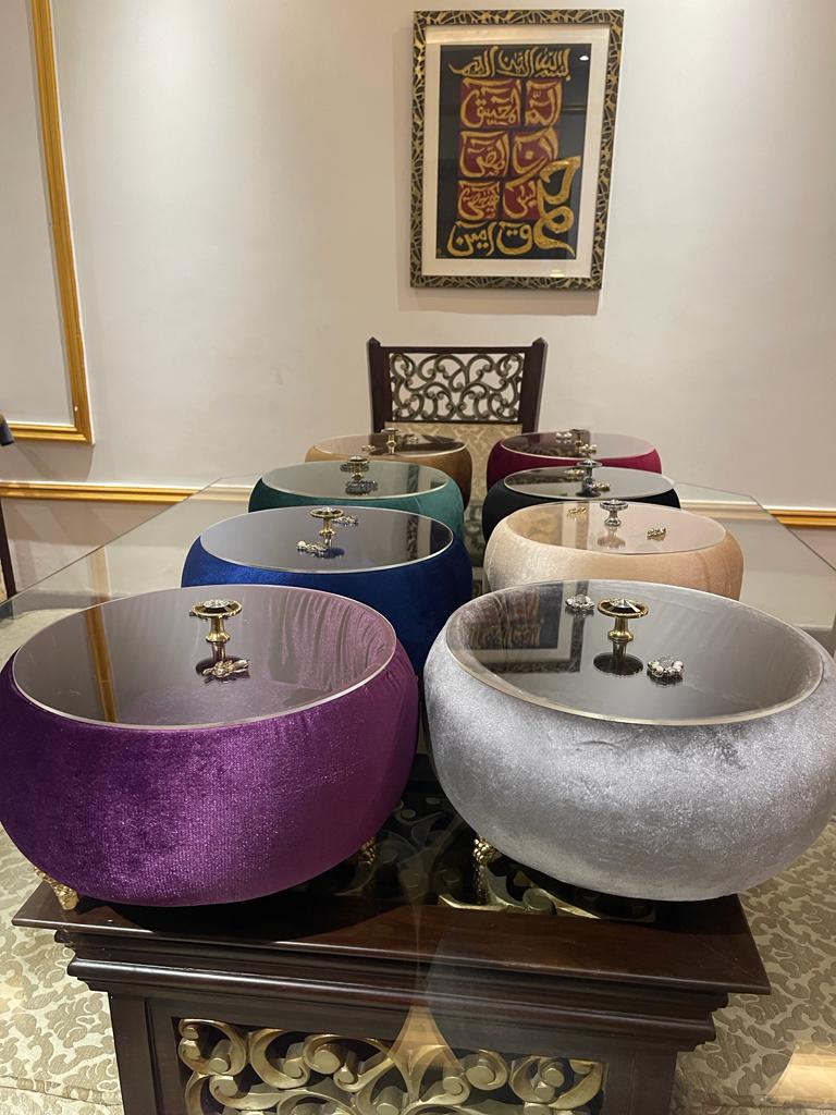 Set of round, colorful Turkish Hotpots on a table with a decorative wall art in the background.
